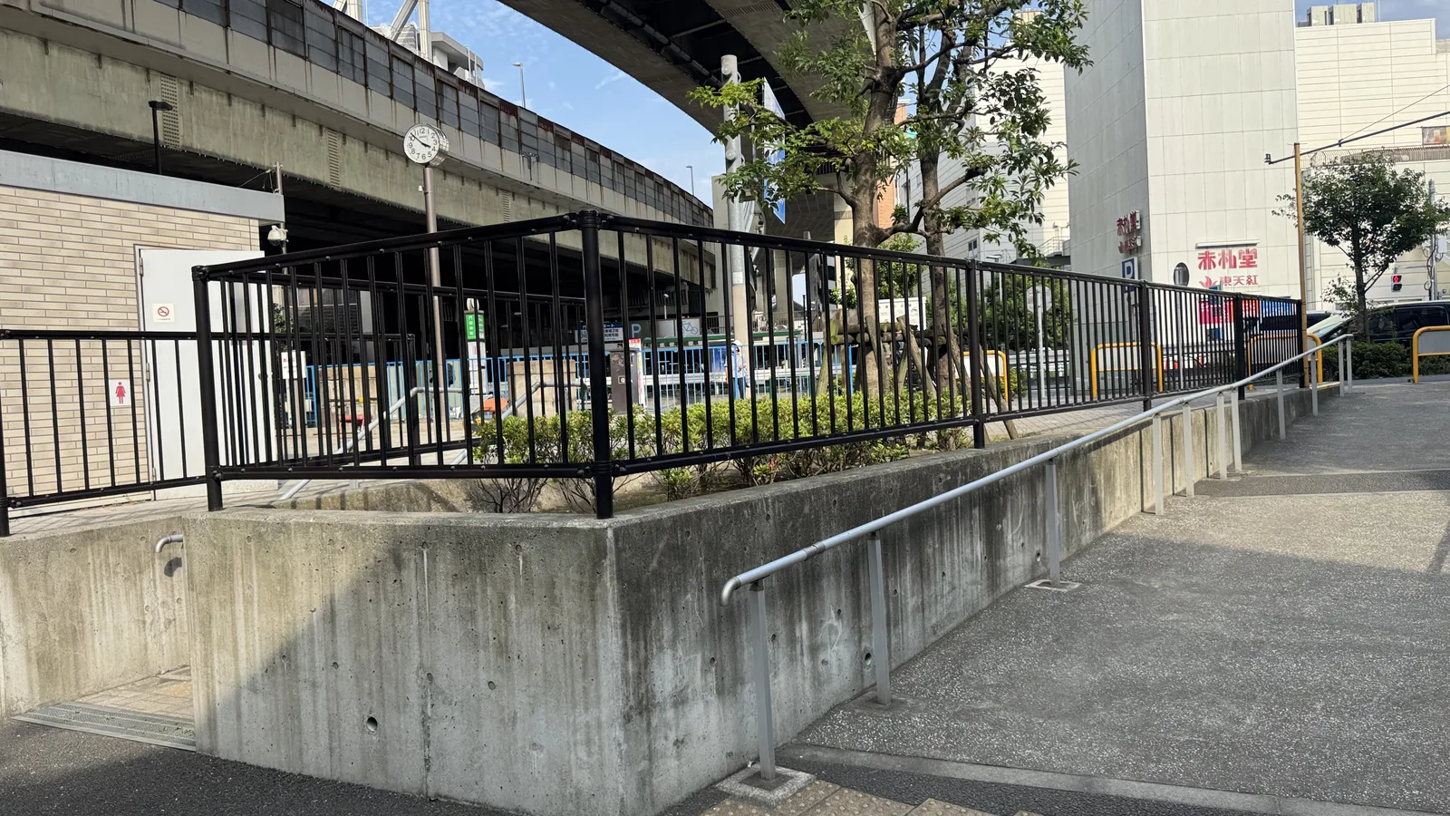 手すりと点字ブロックがある油堀川公園のスロープ
