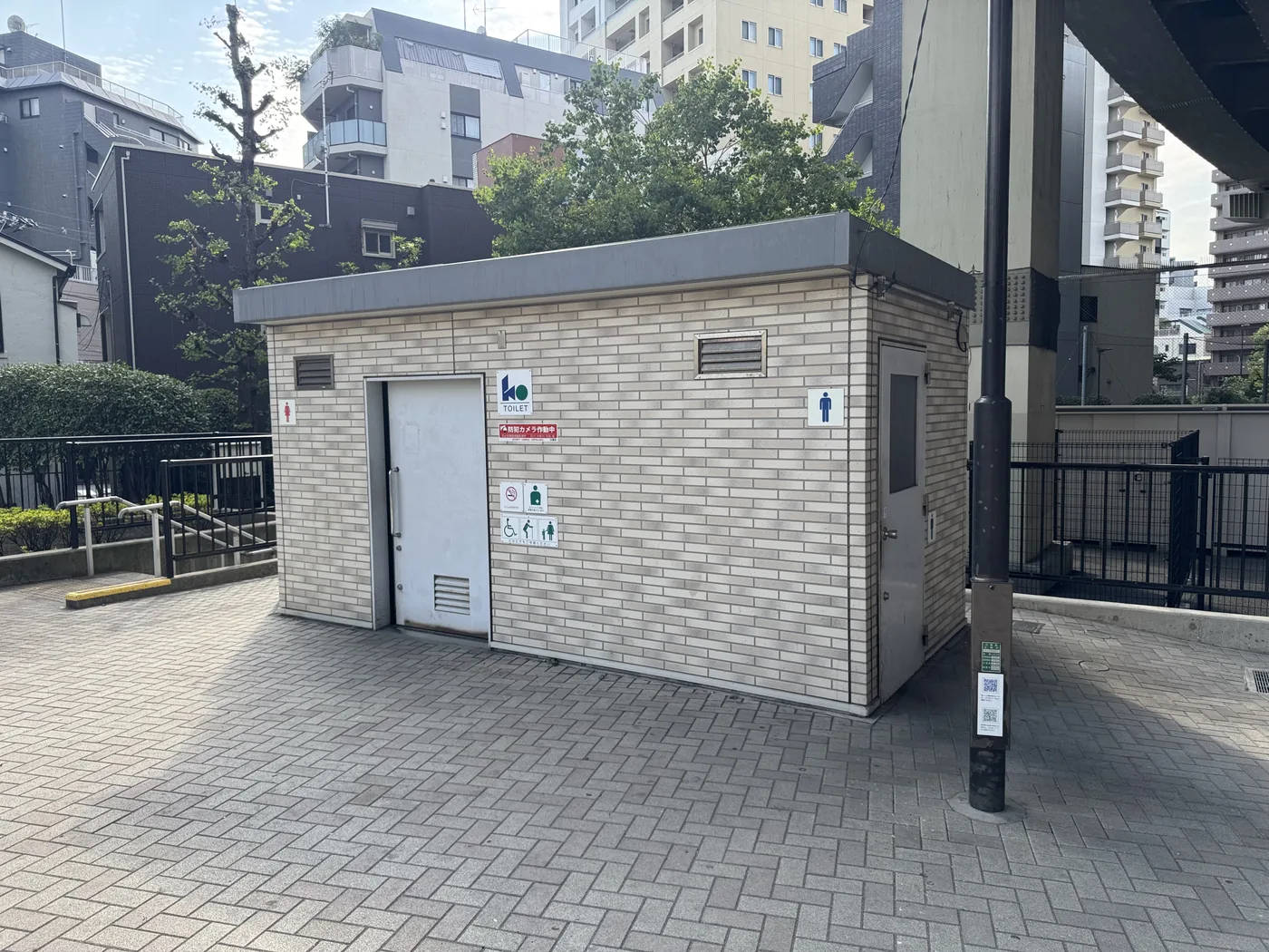 レンガ敷きの前に建つ油堀川公園のトイレ建物