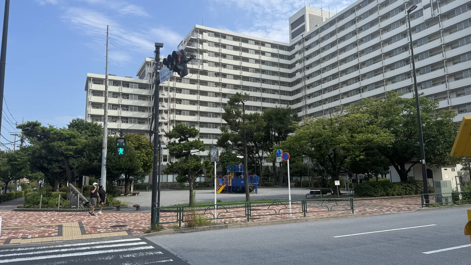 横断歩道から見たあさなぎ公園。船型遊具と大きな集合住宅が並ぶ