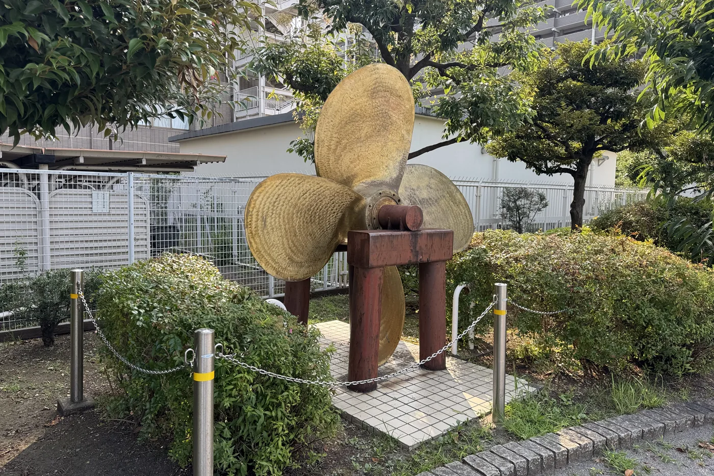 園内に据えられた船のスクリュー記念物。チェーン付きのポールで囲まれている