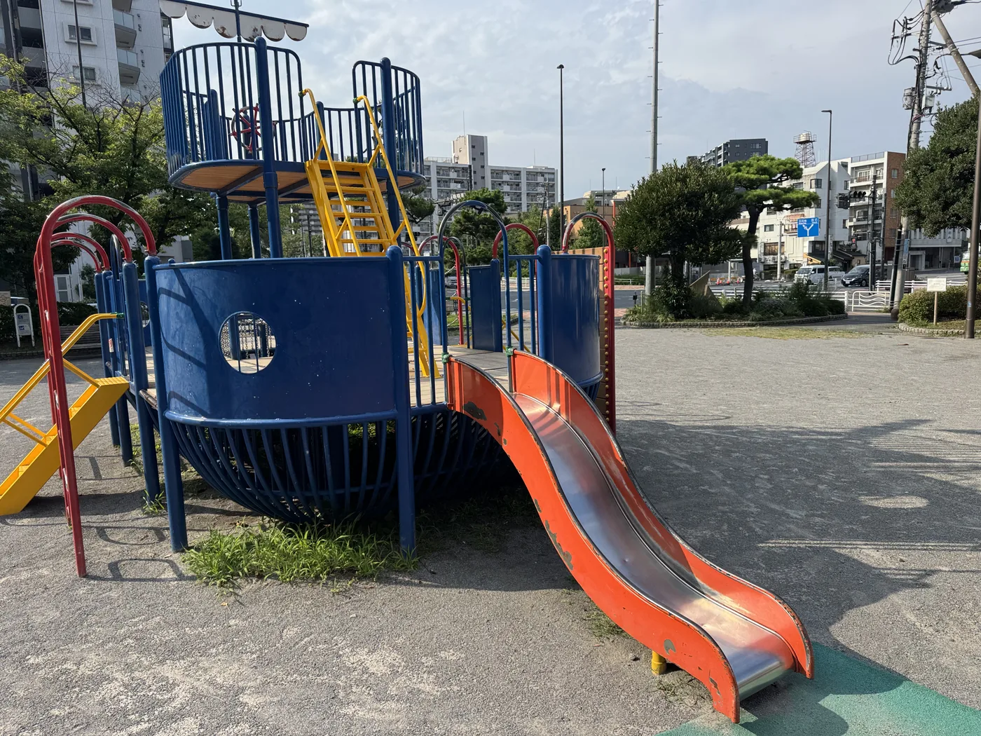 船型遊具のクローズ。上部デッキに操舵輪、オレンジのすべり台がある