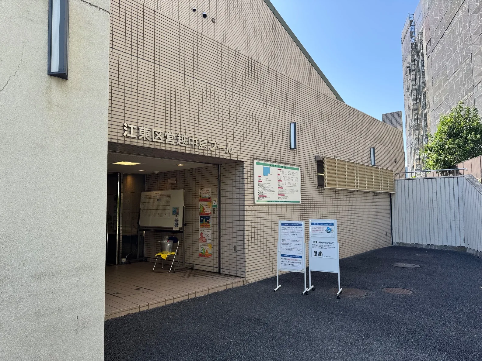 江東区営越中島プールの入口。ベージュのタイル壁