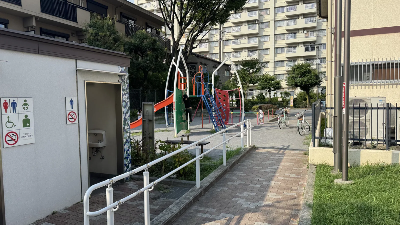 トイレ棟と遊具エリアを見下ろす枝川一丁目公園の全景。集合住宅に囲まれている