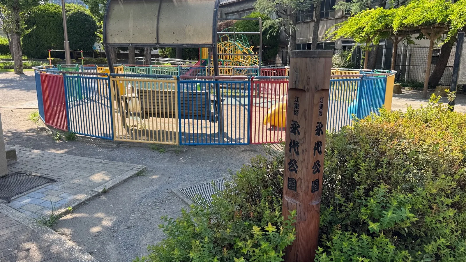 木製の縦看板『江東区 永代公園』と円形の遊び場