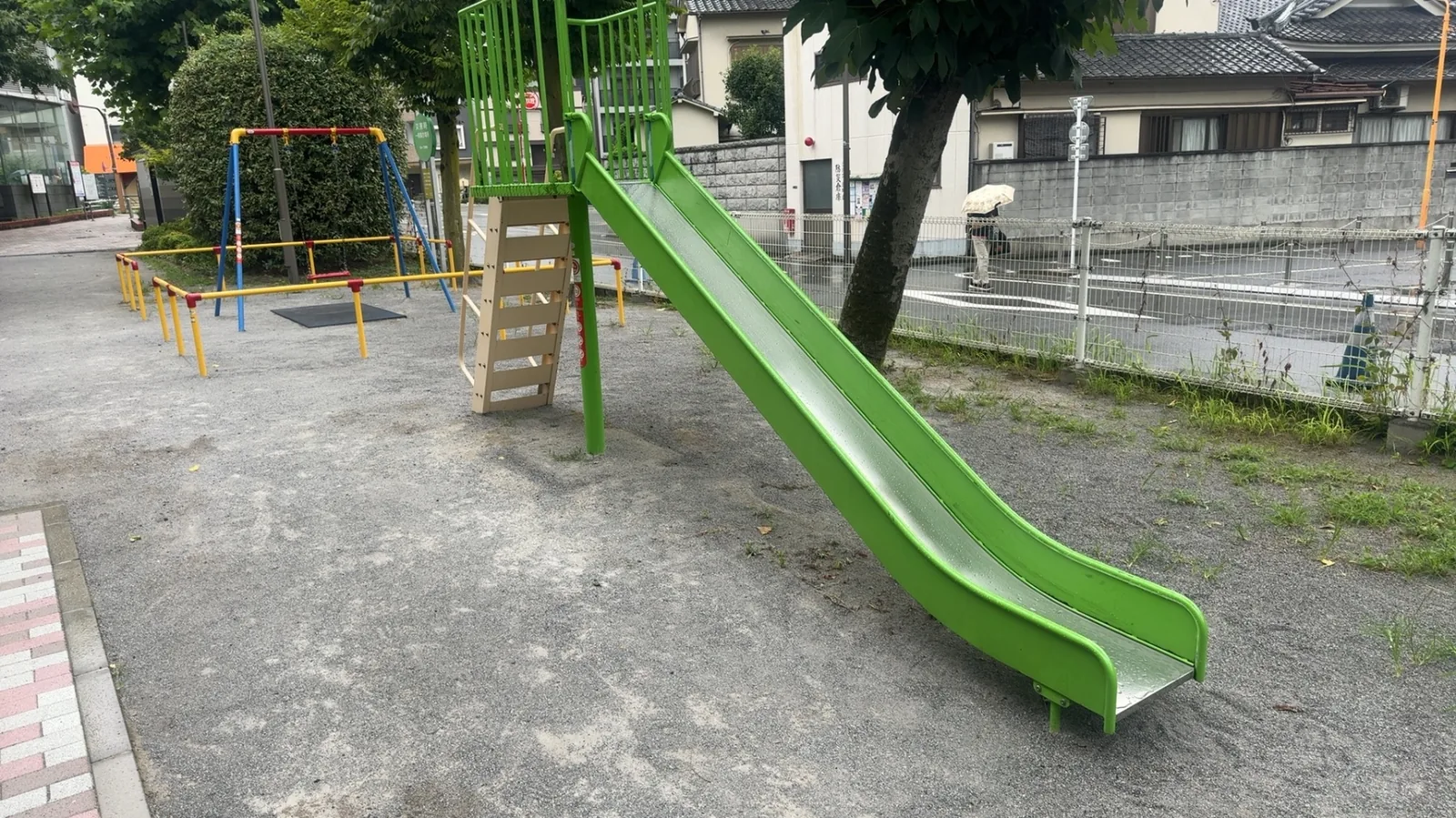 すべり台とブランコが並ぶ遊具エリアの概観