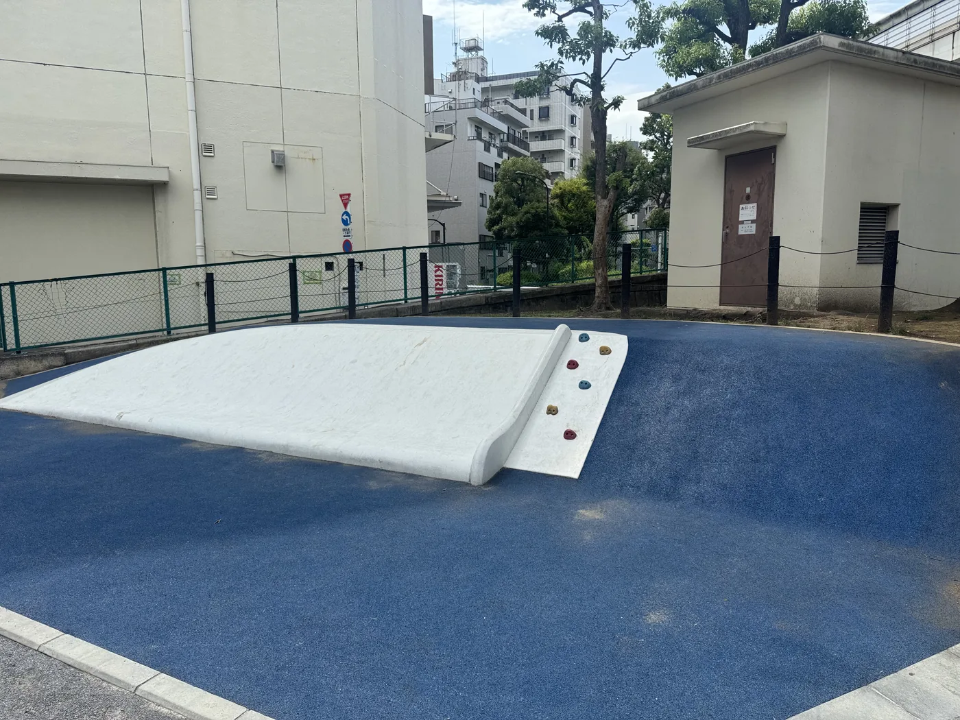 青い安全舗装のすべり台がある亀堀公園の遊具エリア