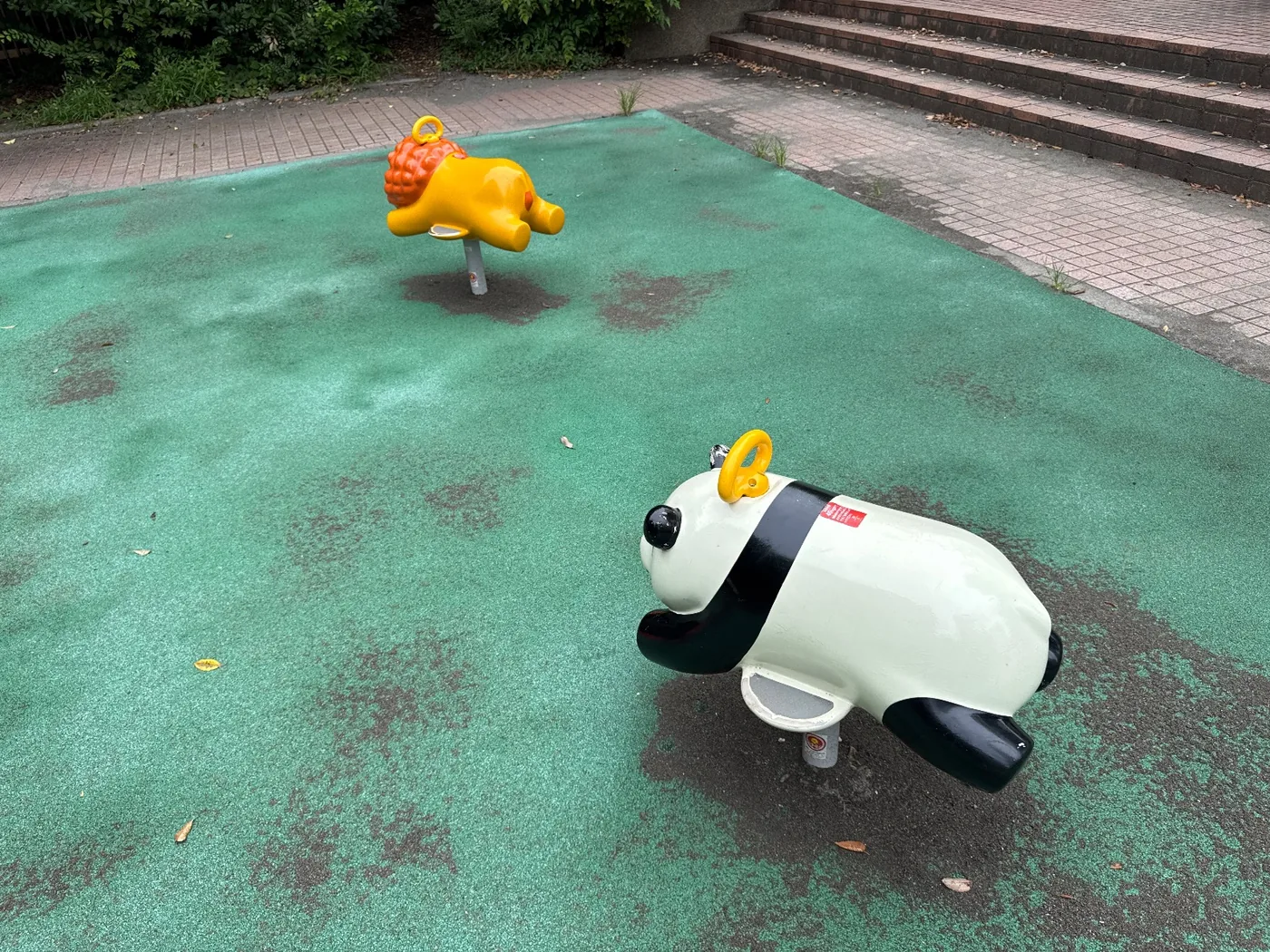 白いパンダと黄色いライオンのスプリング遊具。緑の安全マット