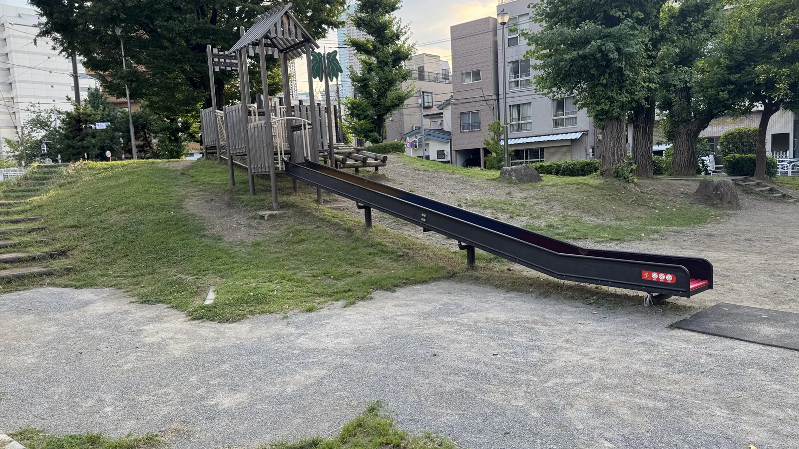 丘の上の木製塔から伸びる金属製滑り台
