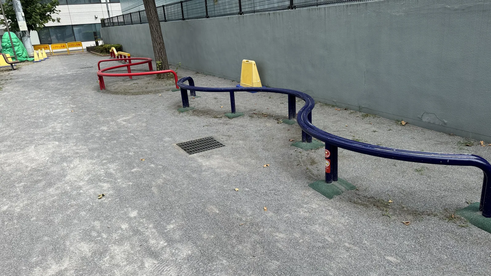 波型の遊具と砂利の園路が続く佐賀町公園の奥側