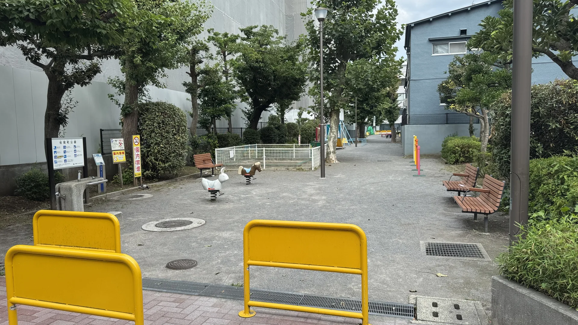 細長い園路と遊具が続く佐賀町公園の入口からの全景