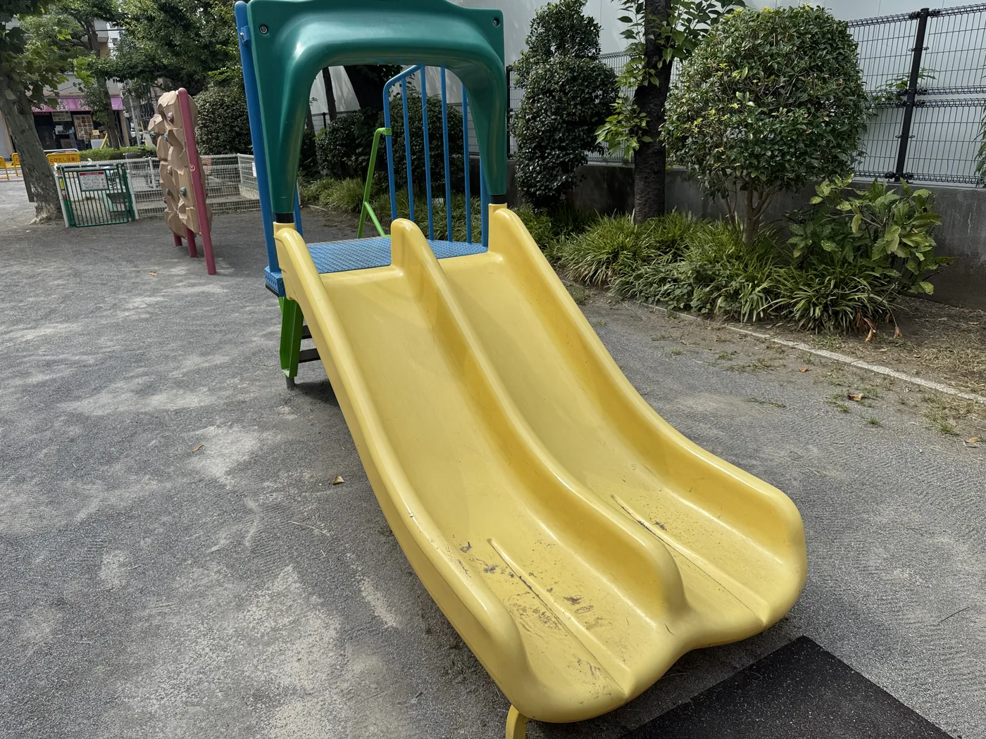 黄と青の2連すべり台がある佐賀町公園の遊具エリア