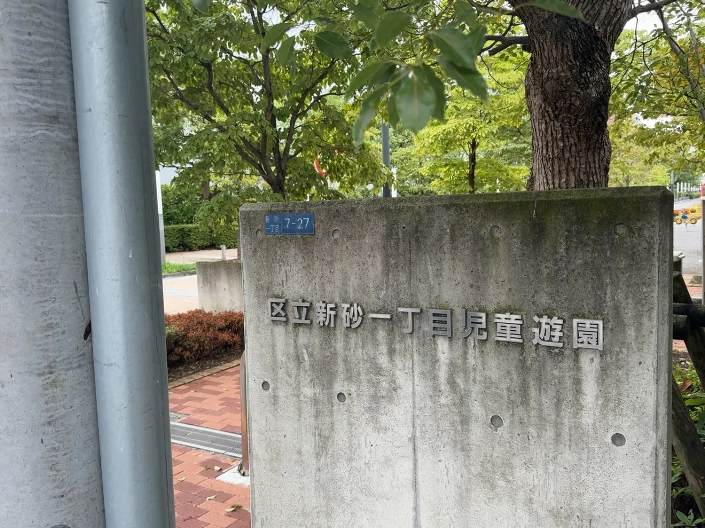 区立新砂一丁目児童遊園と鋳出されたコンクリートの園名板。青い住所板に新砂一丁目7-27