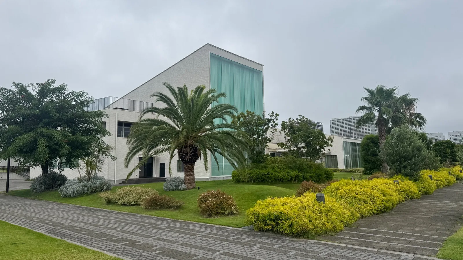 ヤシと芝生、白い建物が並ぶ園地