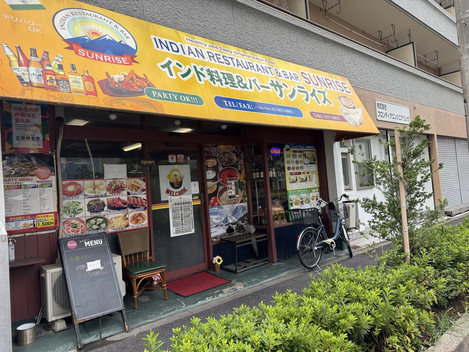 インド料理店サンライズの青い看板と店先。