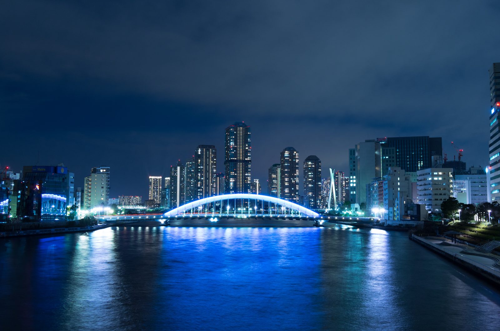 青くライトアップされた現在の永代橋が、隅田川の水面に映る夜景。