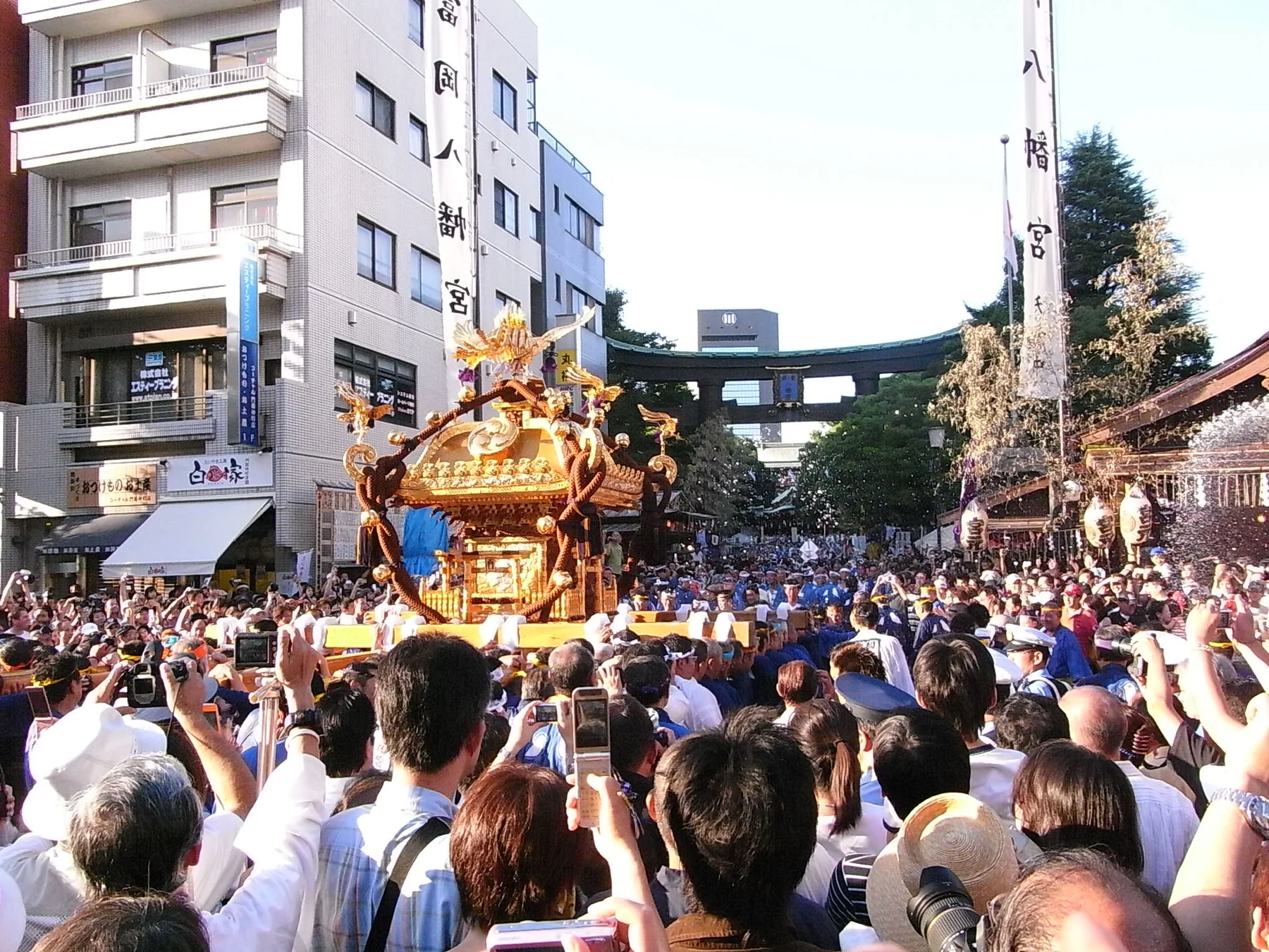 大勢の観衆に囲まれて富岡八幡宮の大鳥居へ進む神輿